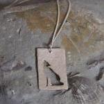 Stylized Wolf Pendant: A Howling Wolf Silhouetted..