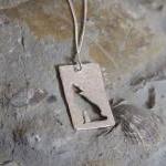 Stylized Wolf Pendant: A Howling Wolf Silhouetted..