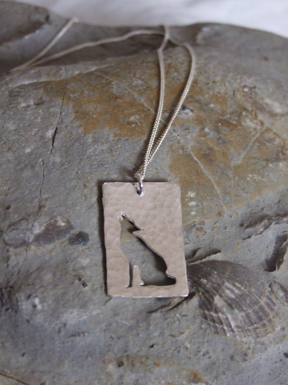 Stylized Wolf Pendant: A Howling Wolf Silhouetted Against A Background Of Textured Sterling Silver