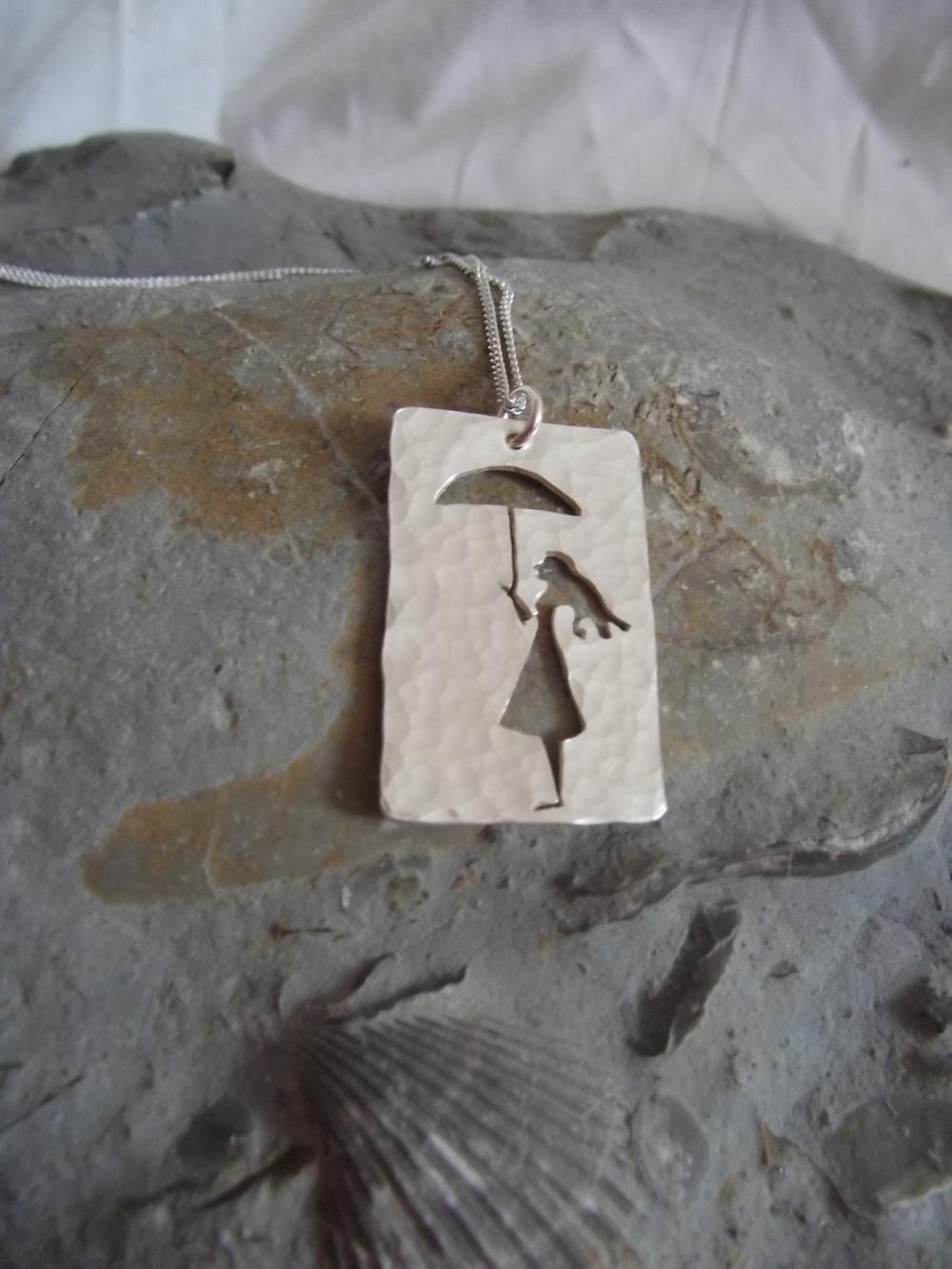 Pendant Girl With Umbrella : A Sterling Silver Pendant With A Little Girl Holding Her Umbrella On A Background Of Textured Silver.